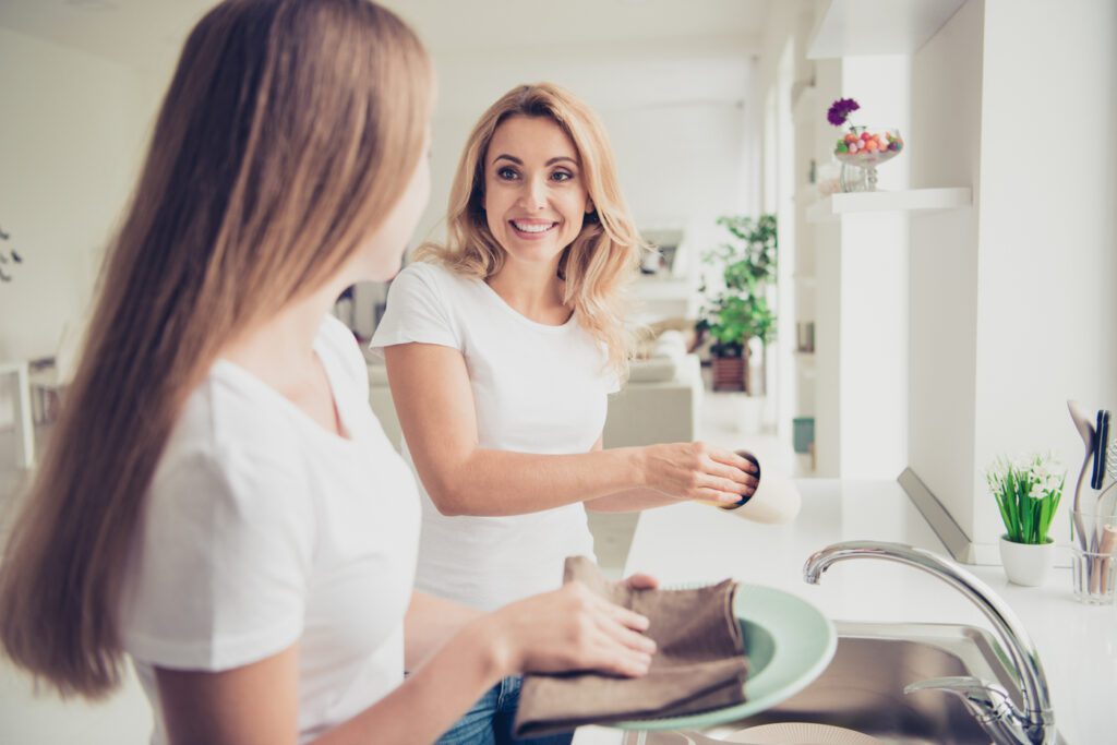 Daughter helping mother do dishes