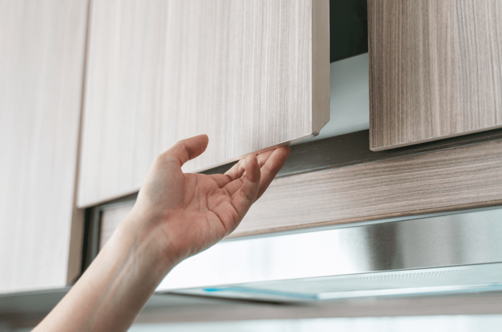 woman's hand opening a kitchen cabinet