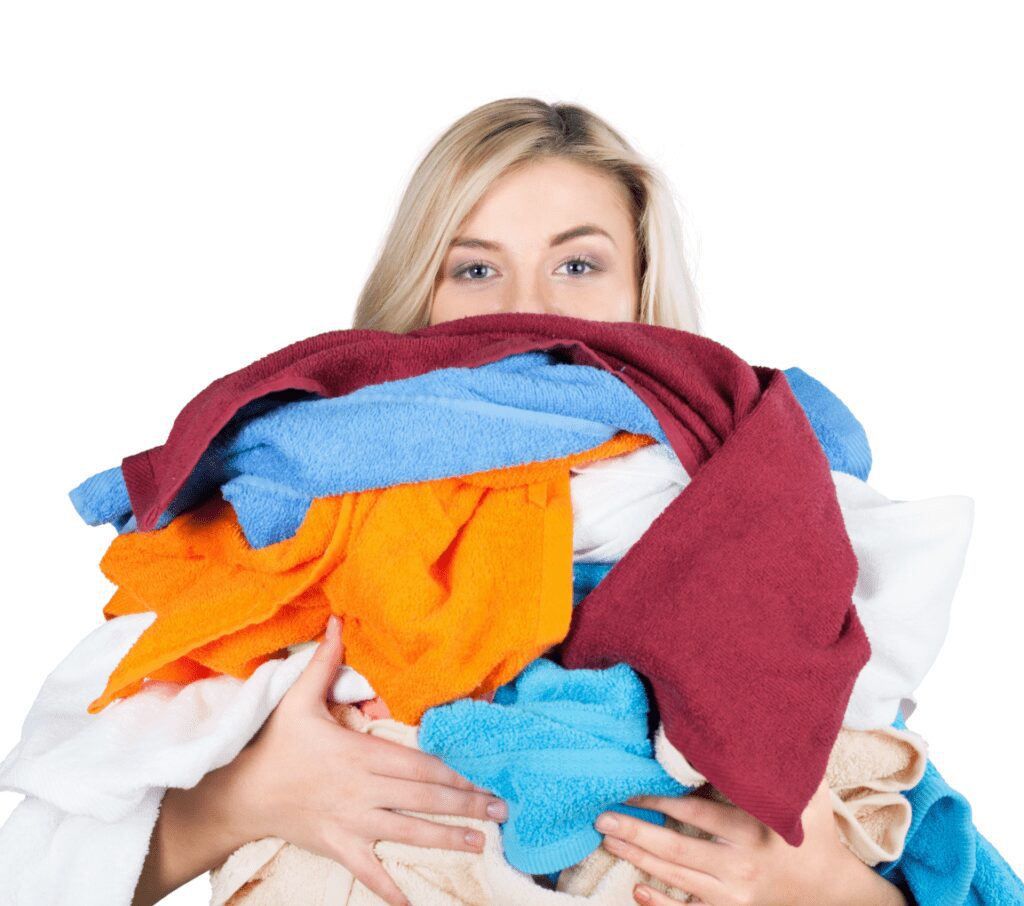 woman holding a pile of unfolded laundry