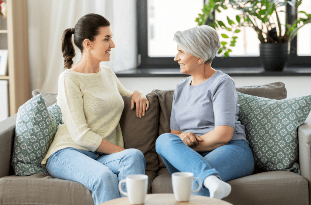 Older woman sitting on a couch and talking with a younger woman