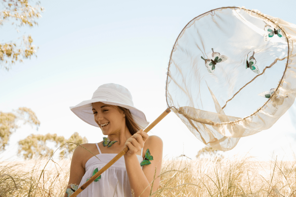 young lady holding a butterfly net and catching butterflies