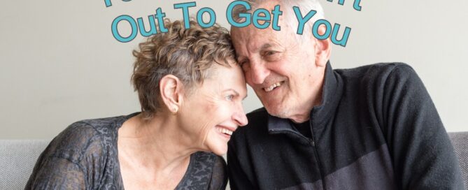 Older couple snuggling a little with caption that says Your Spouse Isn't Out To Get You