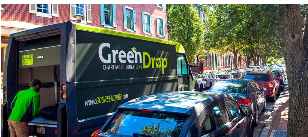 Green Drop truck making a donation pick-up in a neighborhood