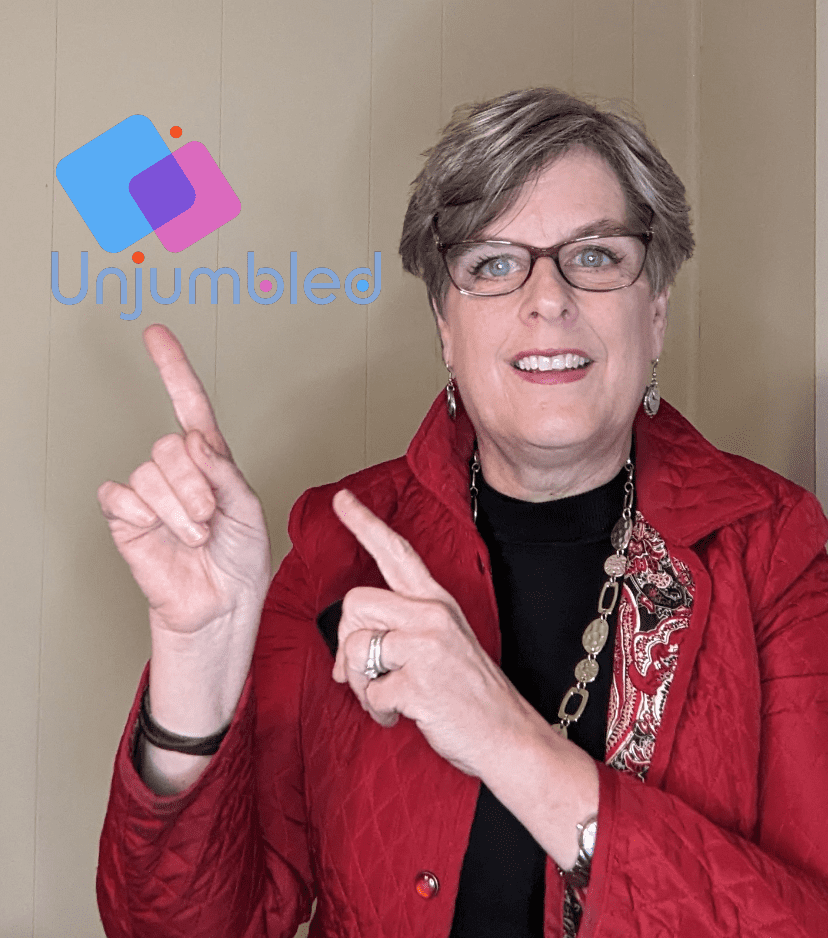 Margaret, the owner of Unjumbled, pointing to the Unjumbled logo