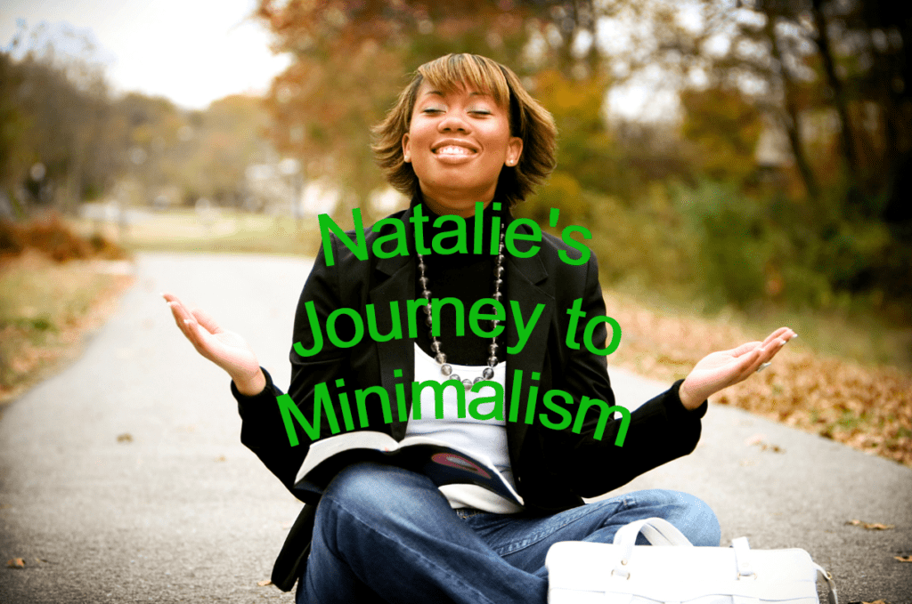 Black woman sitting cross-legged in middle of road with a book on her knee, a smile on her face, and her hands widespread facing the sky