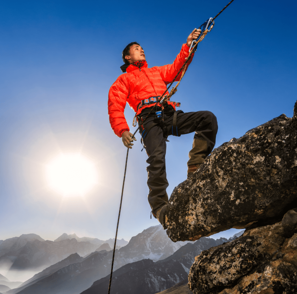 Sherpa climbing a sunlit mountain