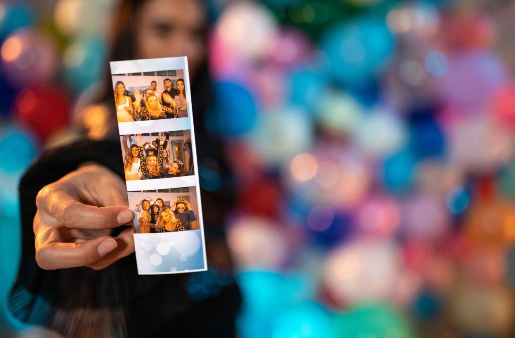Colorful, blurry background with a somewhat blurry woman holding a clear picture roll of family having fun together