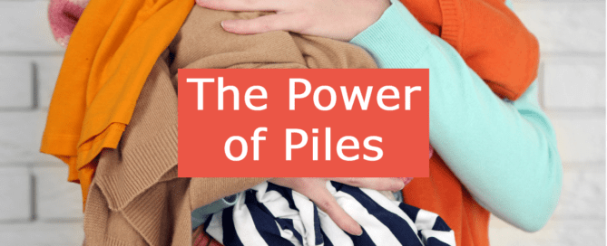 A lady's arms holding a pile of clothes with the words 'The Power of Piles' over the picture