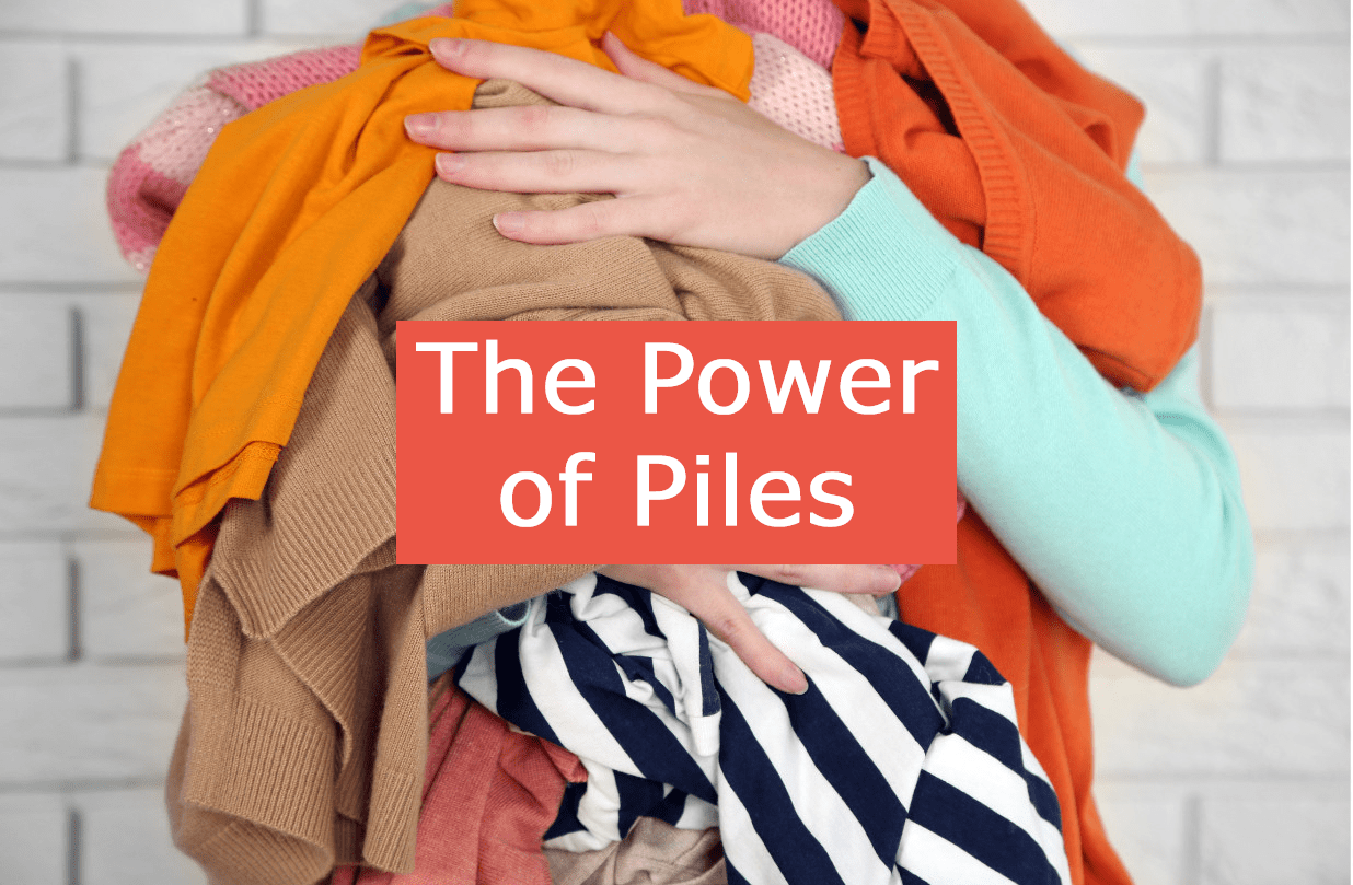 A lady's arms holding a pile of clothes with the words 'The Power of Piles' over the picture