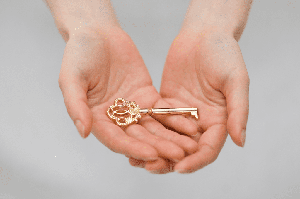 Skeleton key in the palms of two out-stretched hands