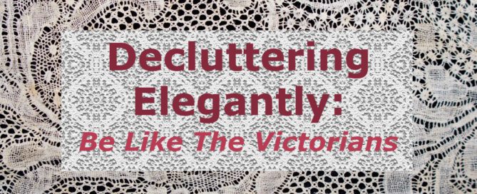 The words "Decluttering Elegantly: Be Like The Victorians" are written over a piece of white lace which is laid over a piece of denser white lace which is placed over a brown table.