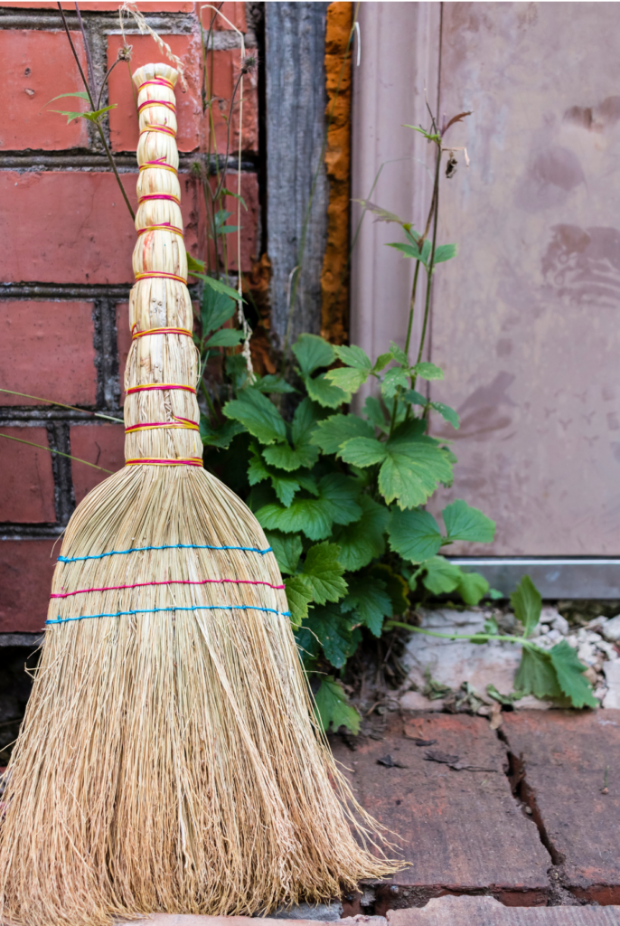small broom leaning against a porch door