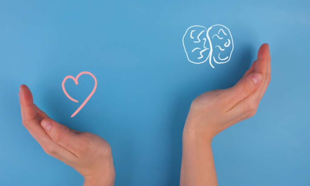 Light blue background with 1 hand balancing a chalk drawing of a heart and the other hand balancing a chalk drawing of a brain.