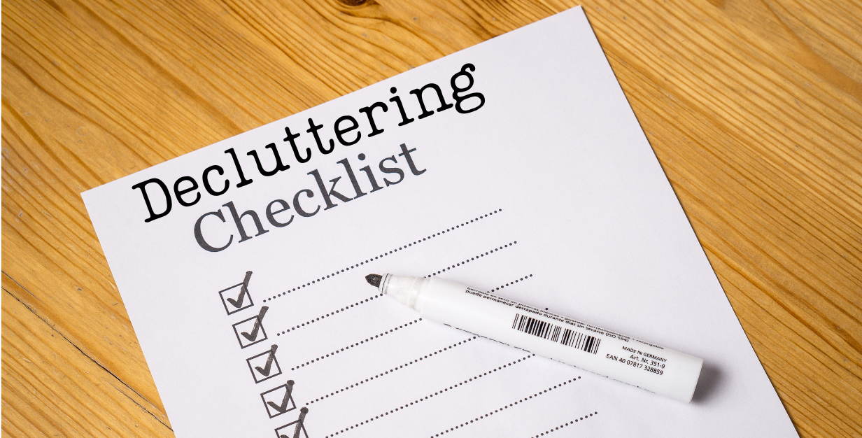 Piece of paper on a desk that has check boxes and the words "Decluttering Checklist" at the top